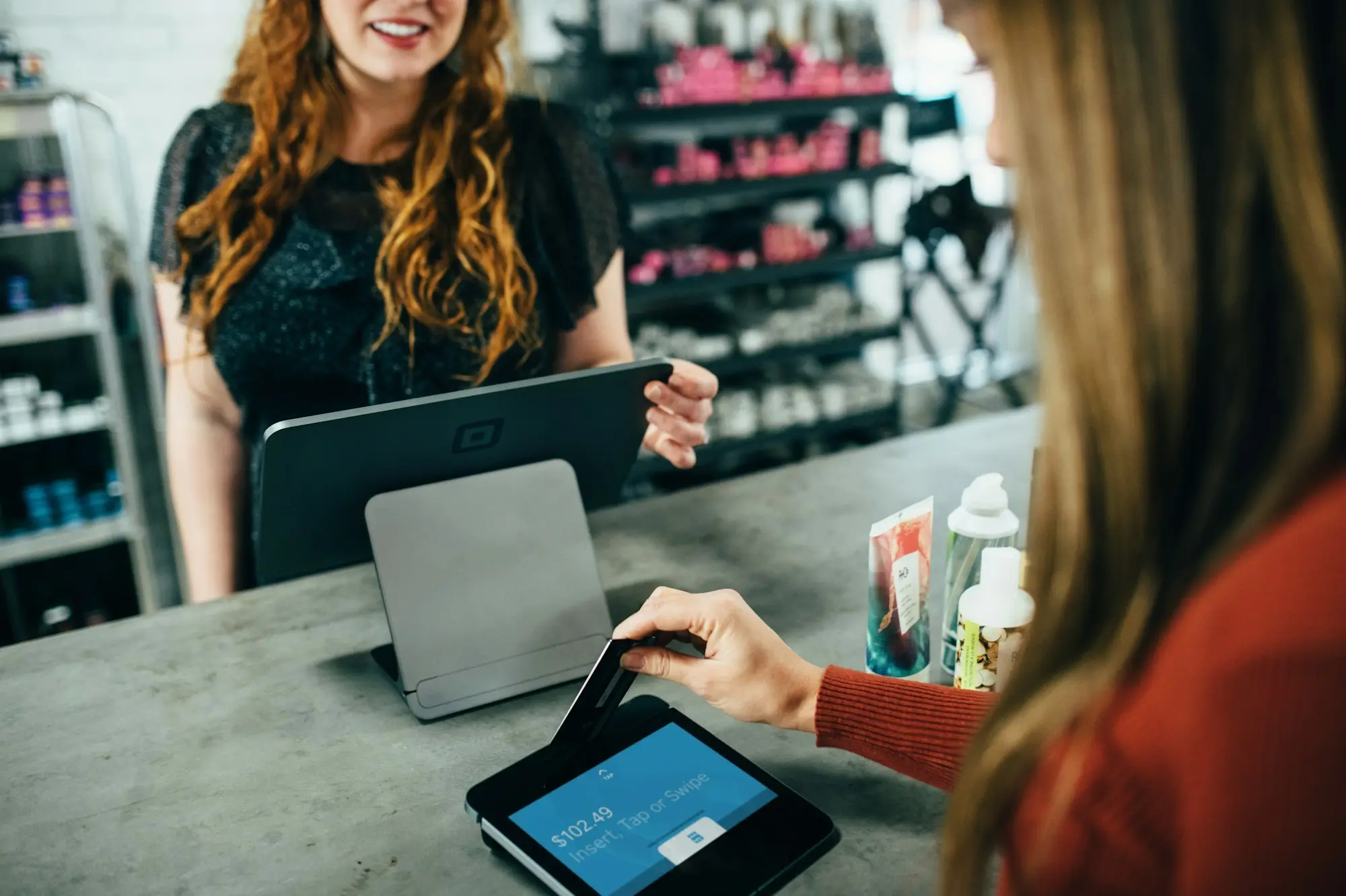 Retail owner serving a customer at the counter of a gift shop in Nelson