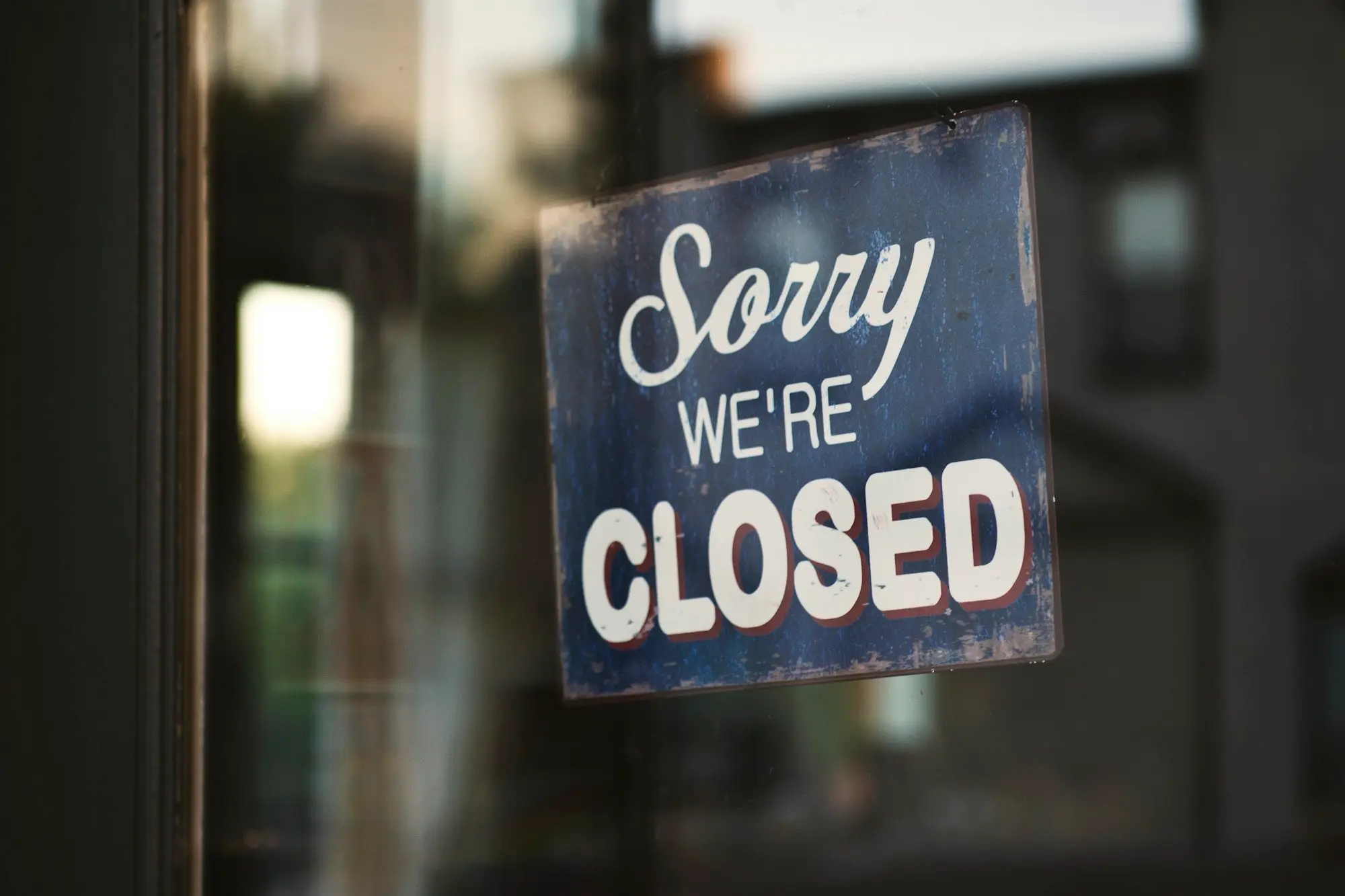 Closed for the holidays sign on the glass door of a small business in Tauranga over summer