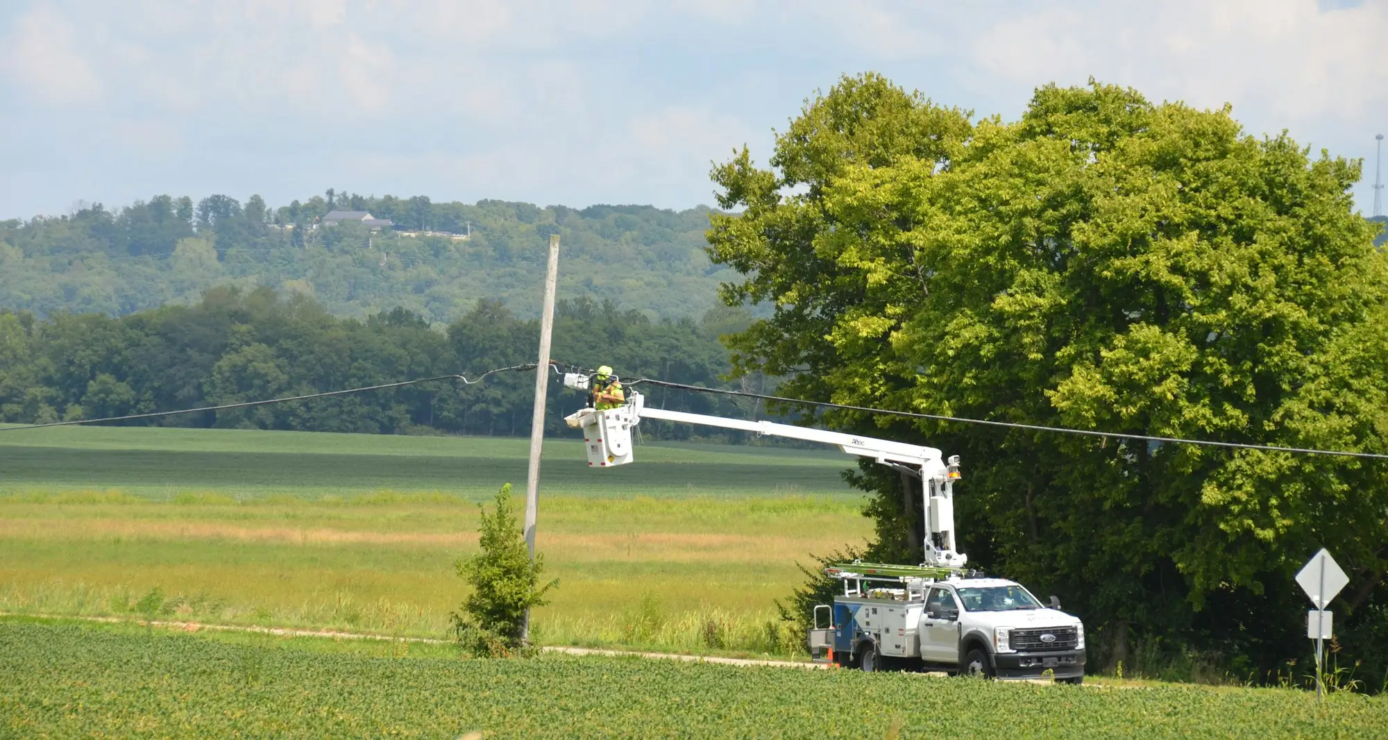 Tradesman unloading tools from a white van on a rural Waikato job site